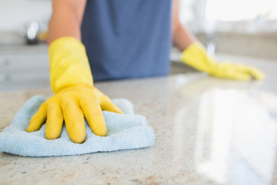 woman cleaning counter with gloves